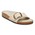 A single Birkenstock Arizona slide sandal in beige leather with a gold buckle and a cork footbed, shown from a side angle on a white background.