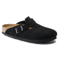 Black clog shoe with a strap on a white background