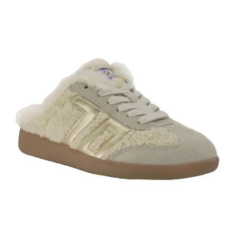 A beige suede and sherpa slip-on sneaker with metallic gold side stripes, cream laces, and a brown gum sole, shown on a white background.